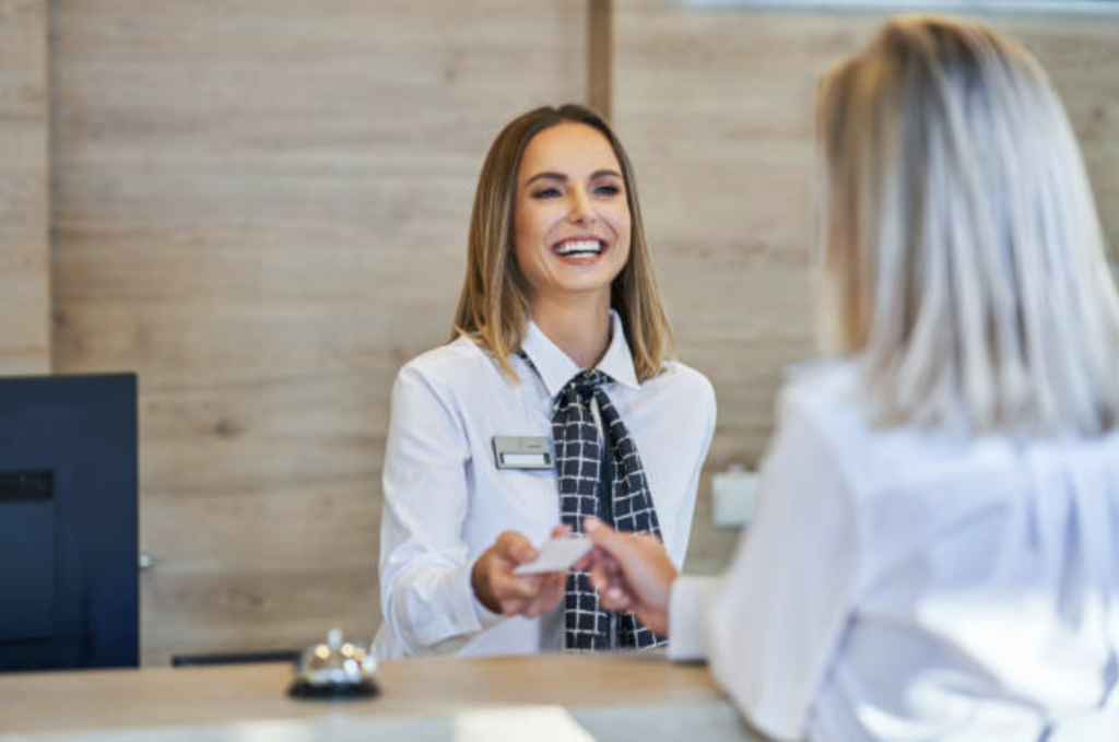 Front desk receptionist greeting a hotel guest